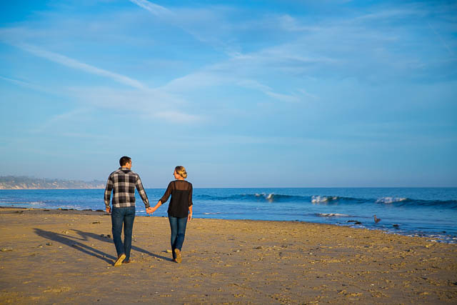 The bride and groom walk together along Goleta Beach.