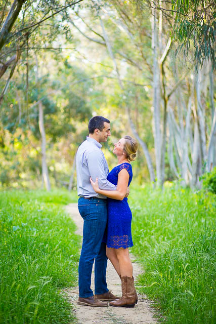 Couple hold each other along the trees at the Ellwood Butterfly Preserve engagement photos.