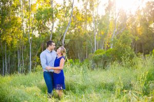 The bride and groom kiss in the tall grass in Goleta for their engagement photos.