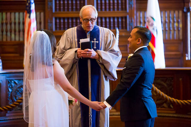 The bride and groom getting married at the Santa Barbara Courthouse Mural Room.