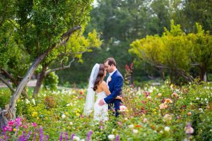 Newlyweds embracing in the rose garden at San Ysidro Ranch.