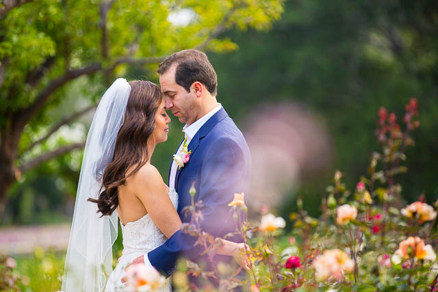 Newlyweds embracing in the rose garden at San Ysidro Ranch.
