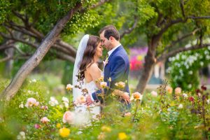 Newlyweds embracing in the rose garden at San Ysidro Ranch.