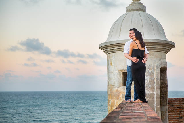 Bride and groom watching the sunset from Castillo San Cristobal in San Juan, Puerto Rico.