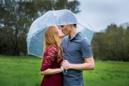 Couple kissing during their Solvang engagement photos in the rain.