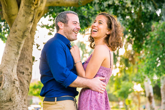 The newly engaged couple laughing together at their Tel Aviv engagement photoshoot.