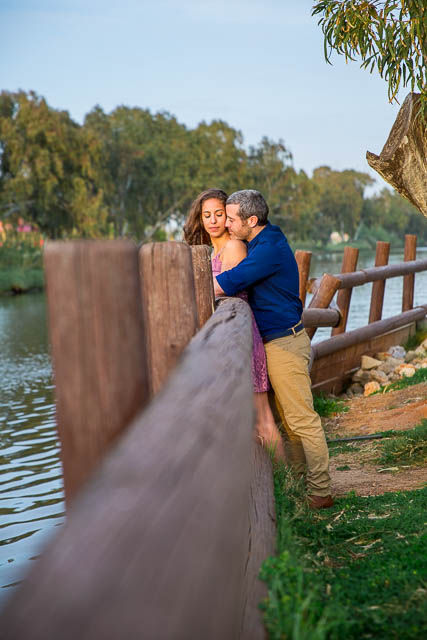 Engaged couple sitting together overlooking the Yarkon River in Tel Aviv, Isarel, during their engagement photos. 