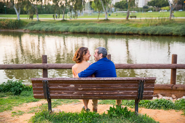 Engaged couple sitting together overlooking the Yarkon River in Tel Aviv, Isarel, during their engagement photos. 