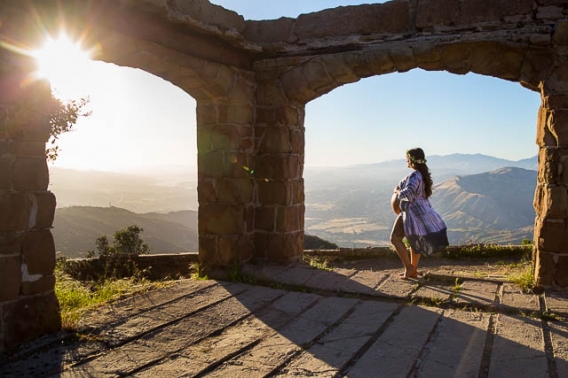 Expectant mother smiles for the camera during her maternity boudoir photoshoot at Knapp
