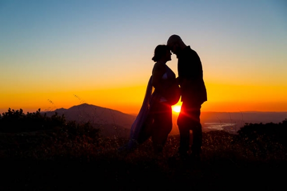 Expectant parents looking over Santa Ynez Valley during their maternity boudoir photoshoot.