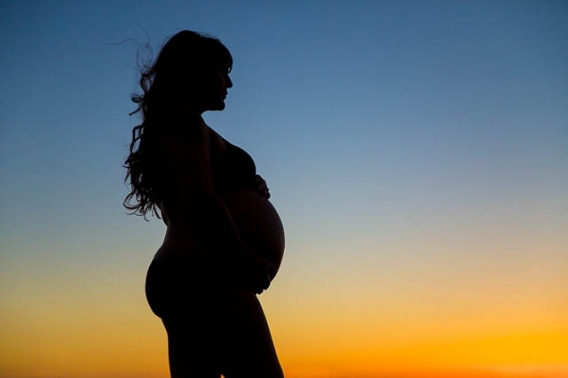 Maternity boudoir silhouette photos on top of a rock in Santa Barbara.