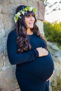 Expectant mother smiles for the camera during her maternity boudoir photoshoot in Santa Barbara.