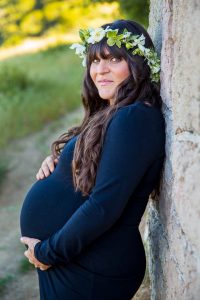 Expectant mother smiles for the camera during her maternity boudoir photoshoot at Knapp's Castle in Santa Barbara.