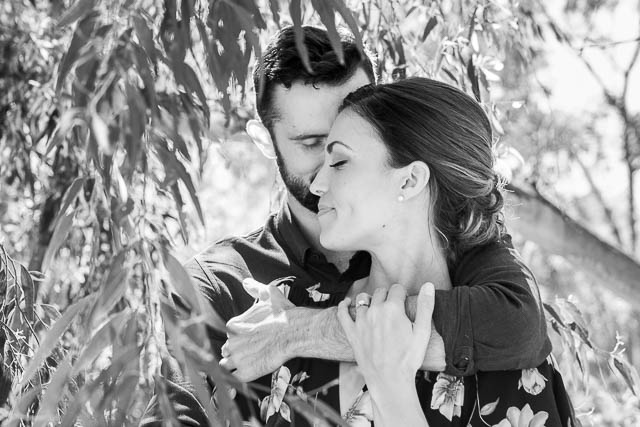 Engaged couple laughing together at the Goleta Butterfly Grove.