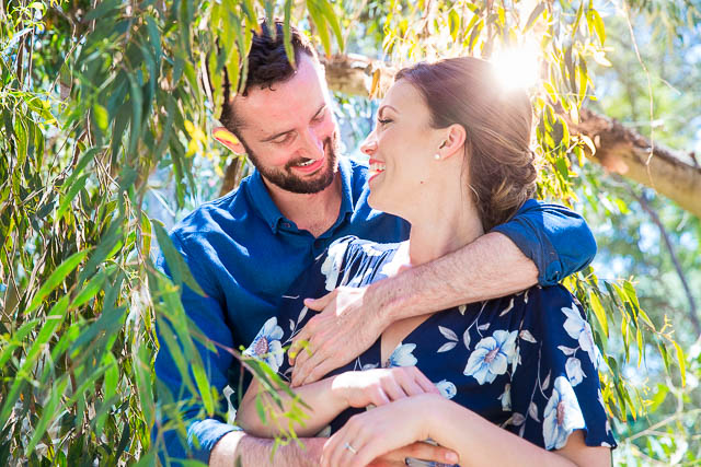 Engaged couple laughing together at the Goleta Butterfly Grove.
