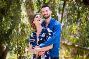 Engaged couple laughing together at the Goleta Butterfly Grove.