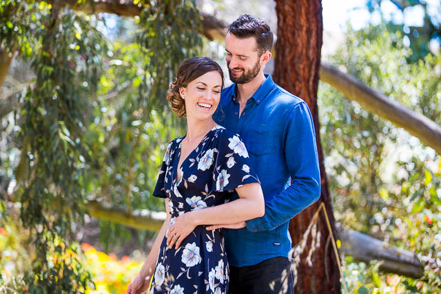 Engaged couple laughing together during their Goleta Butterfly Grove engagement photos.
