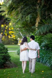 Engaged couple walking together around the Santa Barbara Courthouse grounds.