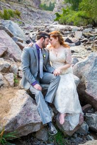 Bride and groom sitting on rocks in the Colorado Rockies.