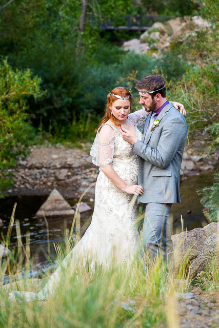 Bride and groom posing with the Rockie Mountains behind them.