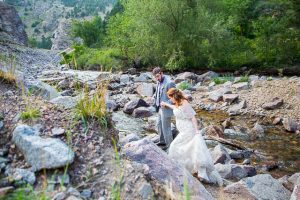 Newlyweds walking on boulders in Boulder, Colorado.