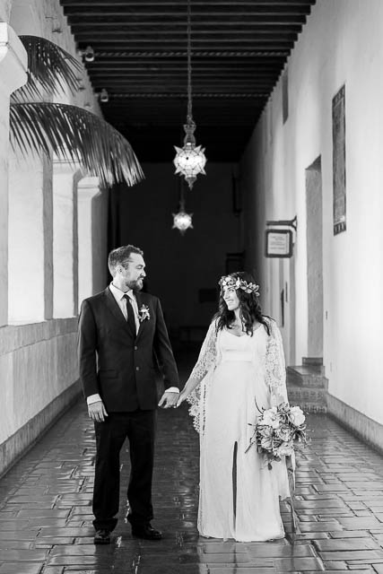 Newlywed couple walking around the interior of the Santa Barbara Courthosue.