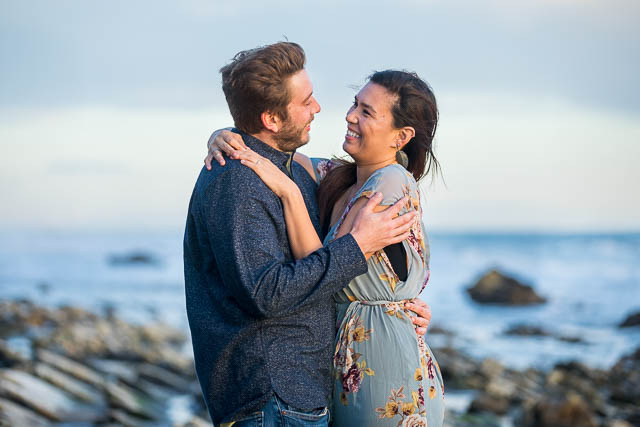 Bride and groom laughing together during their engagement photos at Hendry's Beach in Santa Barbara.