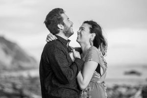 Bride and groom laughing together during their engagement photos at Hendry's Beach in Santa Barbara.