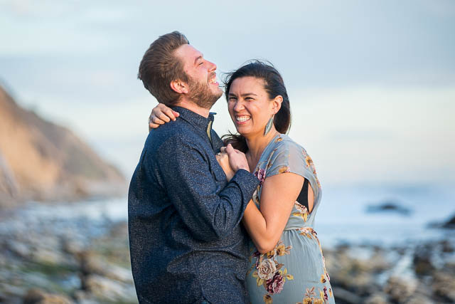 Bride and groom laughing together during their engagement photos at Hendry's Beach in Santa Barbara.