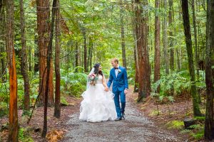Bride and groom walk together through the Rotorua Redwoods Forest in New Zealand.