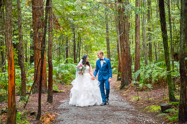 Bride and groom walk together through the Rotorua Redwoods Forest in New Zealand.