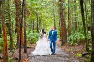 Bride and groom walk together through the Rotorua Redwoods Forest in New Zealand.