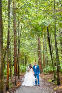 Bride and groom walk together through the Rotorua Redwoods Forest in New Zealand.