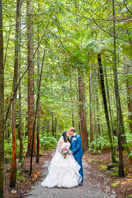 Bride and groom walk together through the Rotorua Redwoods Forest in New Zealand.