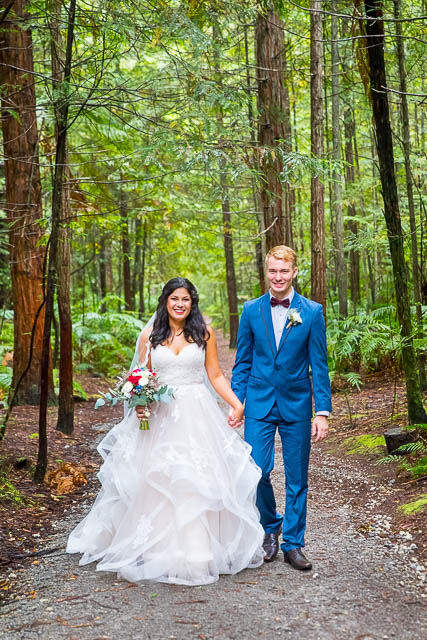 Bride and groom walk together through the Rotorua Redwoods Forest in New Zealand.