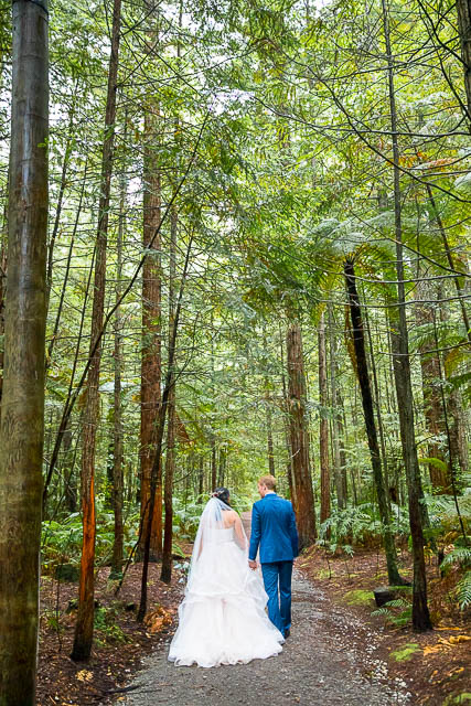 Bride and groom walk together through the Rotorua Redwoods Forest in New Zealand.