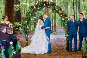Bride and groom's first kiss at their Rotorua Redwoods Forest Under the Sails wedding ceremony.
