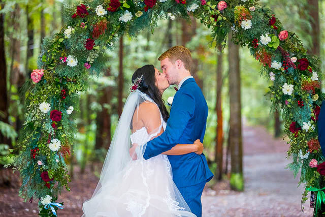 Bride and groom's first kiss at their Rotorua Redwoods Forest Under the Sails wedding ceremony.