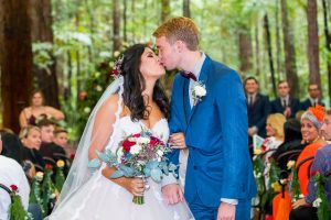 Bride and groom's first kiss at their Rotorua Redwoods Forest Under the Sails wedding ceremony.