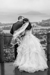 Bride and groom looking over the view from the Skyline Rotorua wedding venue.