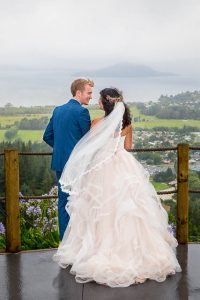 Bride and groom looking over the view from the Skyline Rotorua wedding venue.