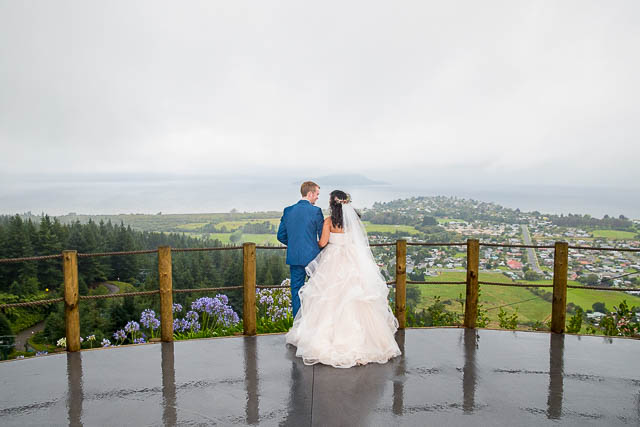 Bride and groom looking over the view from the Skyline Rotorua wedding venue.