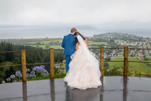 Bride and groom looking over the view from the Skyline Rotorua wedding venue.