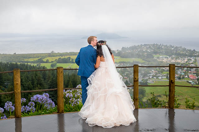 Bride and groom looking over the view from the Skyline Rotorua wedding venue.