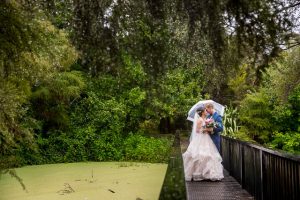 Bride and groom hugging on a bridge in Rotorua, New Zelanad.