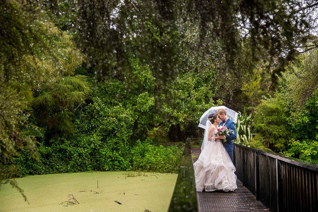 Bride and groom hugging on a bridge during their New Zealand Rotorua Wedding.