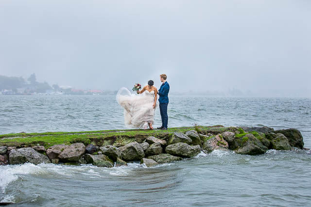 The newlyweds taking photos at Lake Rotorua, New Zealand, on a rainy day.