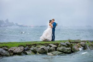 The newlyweds taking photos at Lake Rotorua, New Zealand, on a rainy day.