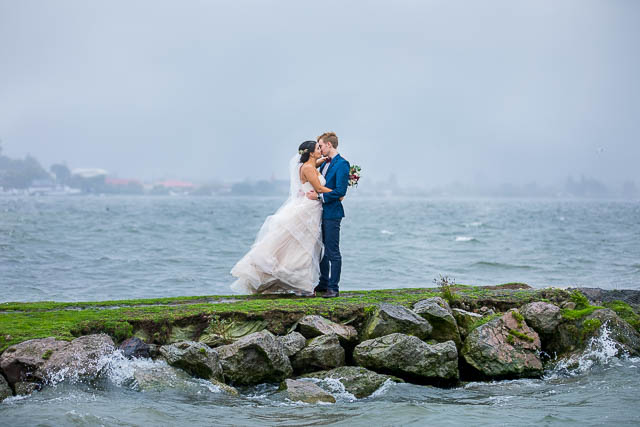 The newlyweds taking photos at Lake Rotorua, New Zealand, on a rainy day.