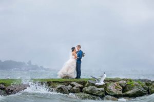 The newlyweds taking photos at Lake Rotorua, New Zealand, on a rainy day.
